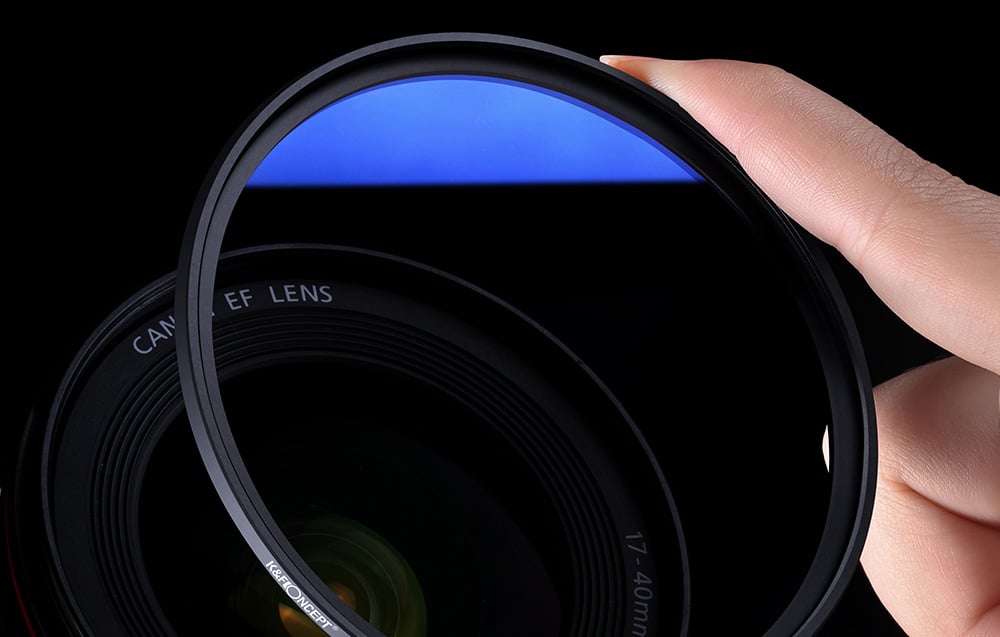 Holding a blue optical filter in hand, camera lens in the background