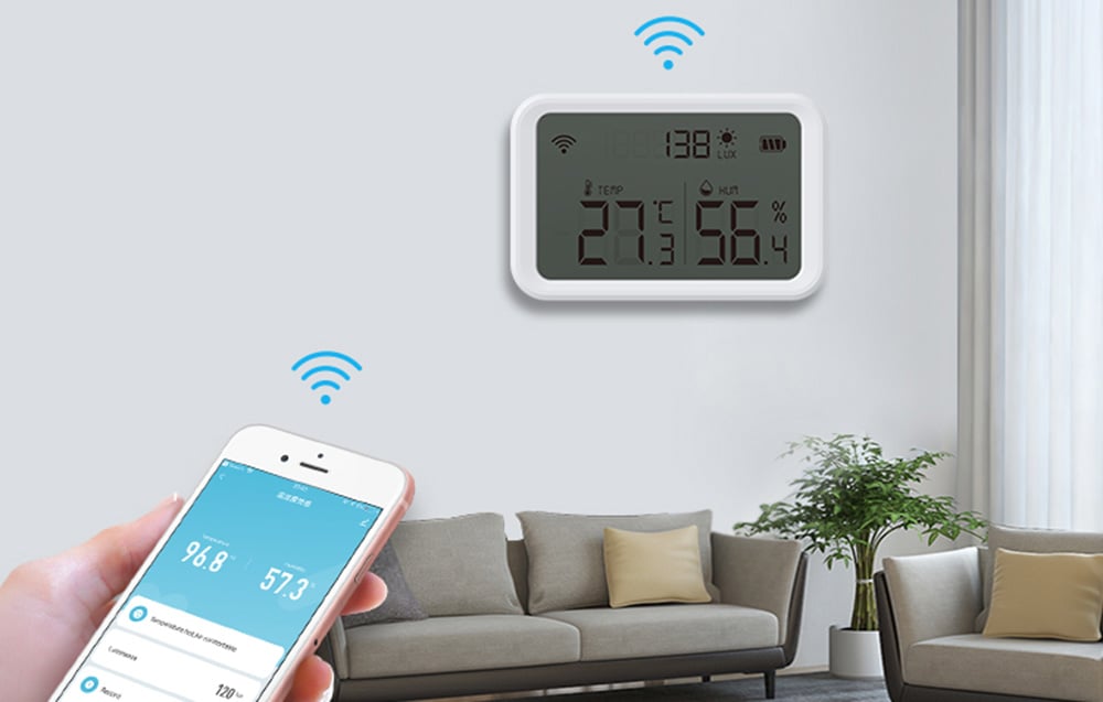 Czujnik temperatury i wilgotności NEO NAS-TH02W z wyświetlaczem Zigbee TUYA na ścianie. Nad nim znak Wi-Fi. Na pierwszym planie widoczna dłoń, która trzyma smartfona, nad którym także widać symbol Wi-Fi.