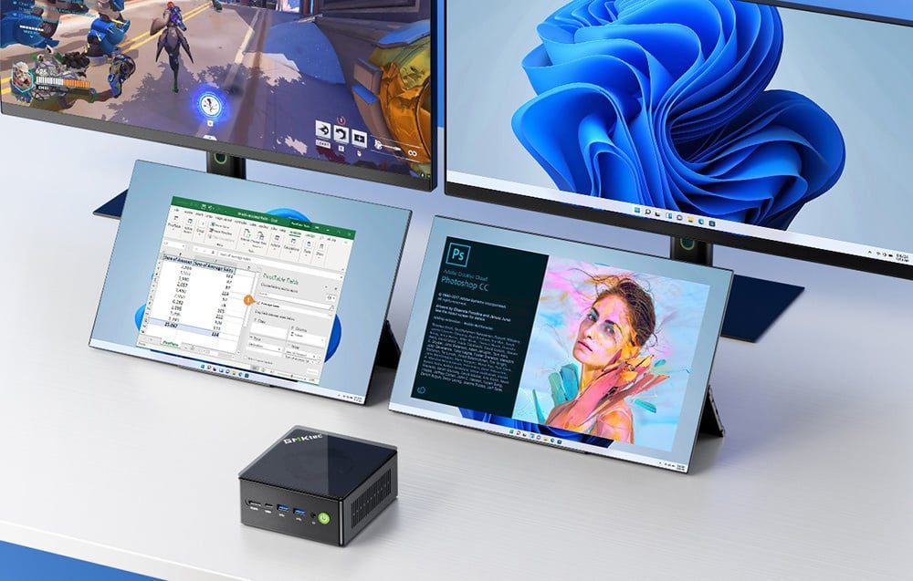 two monitors and two portable monitors set on a bright desk behind the mini PC